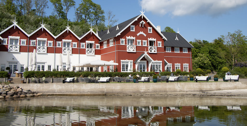 Dyvig Badehotel, Danish building with classic red and white exterior, modern hotel, outdoor lounge with sea view