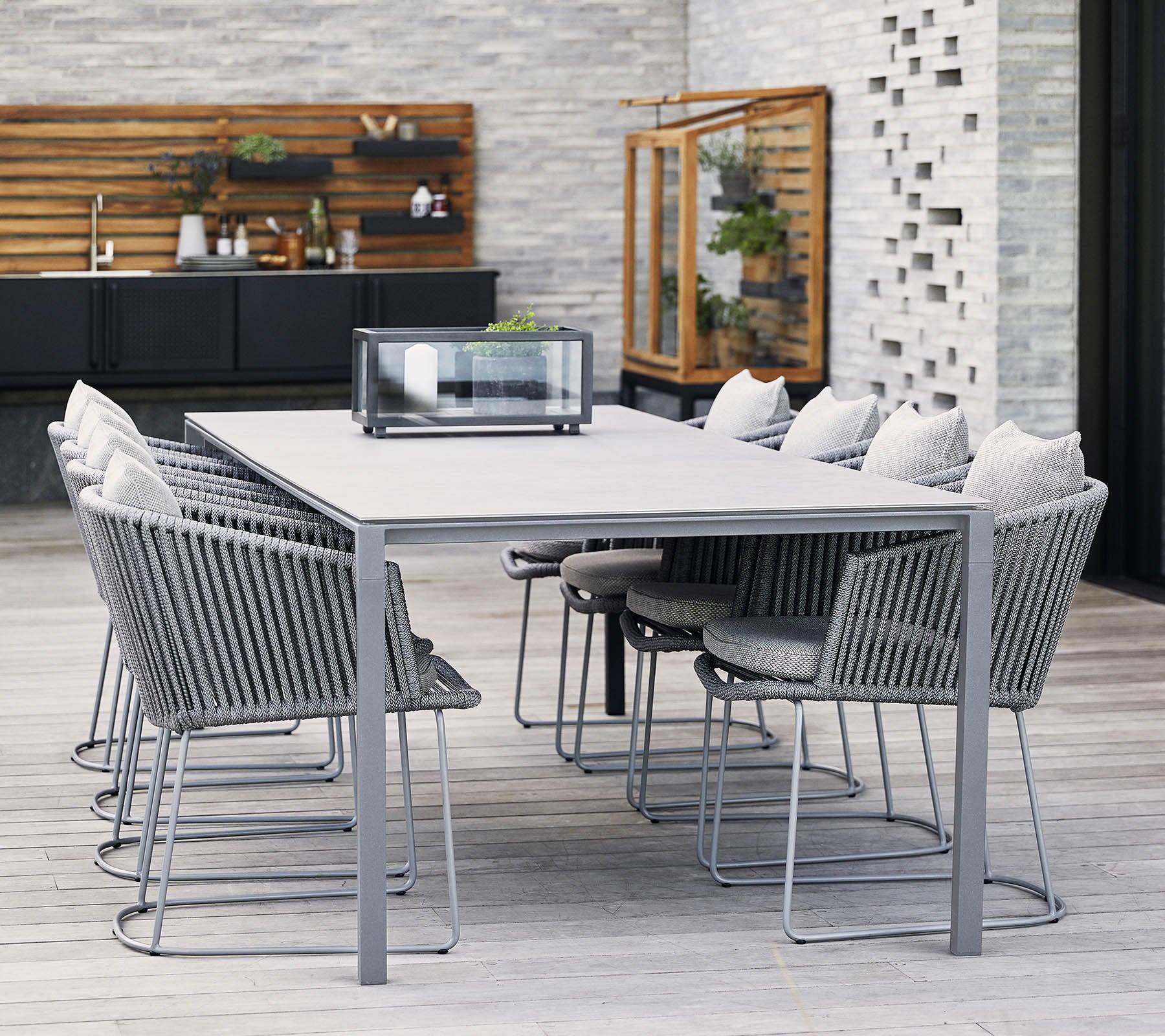 Een moderne eettafel met een grijs metalen frame en comfortabele stoelen, met zachte kussens en een minimalistisch ontwerp, perfect voor bijeenkomsten.