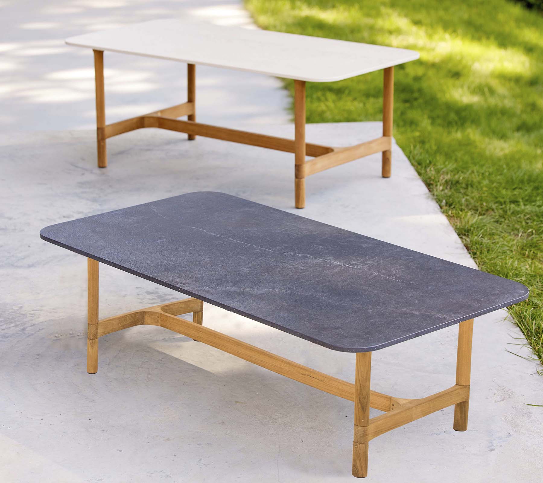 Twee stijlvolle salontafels met houten frames en contrasterende tafelbladkleuren, met een modern, minimalistisch ontwerp.
