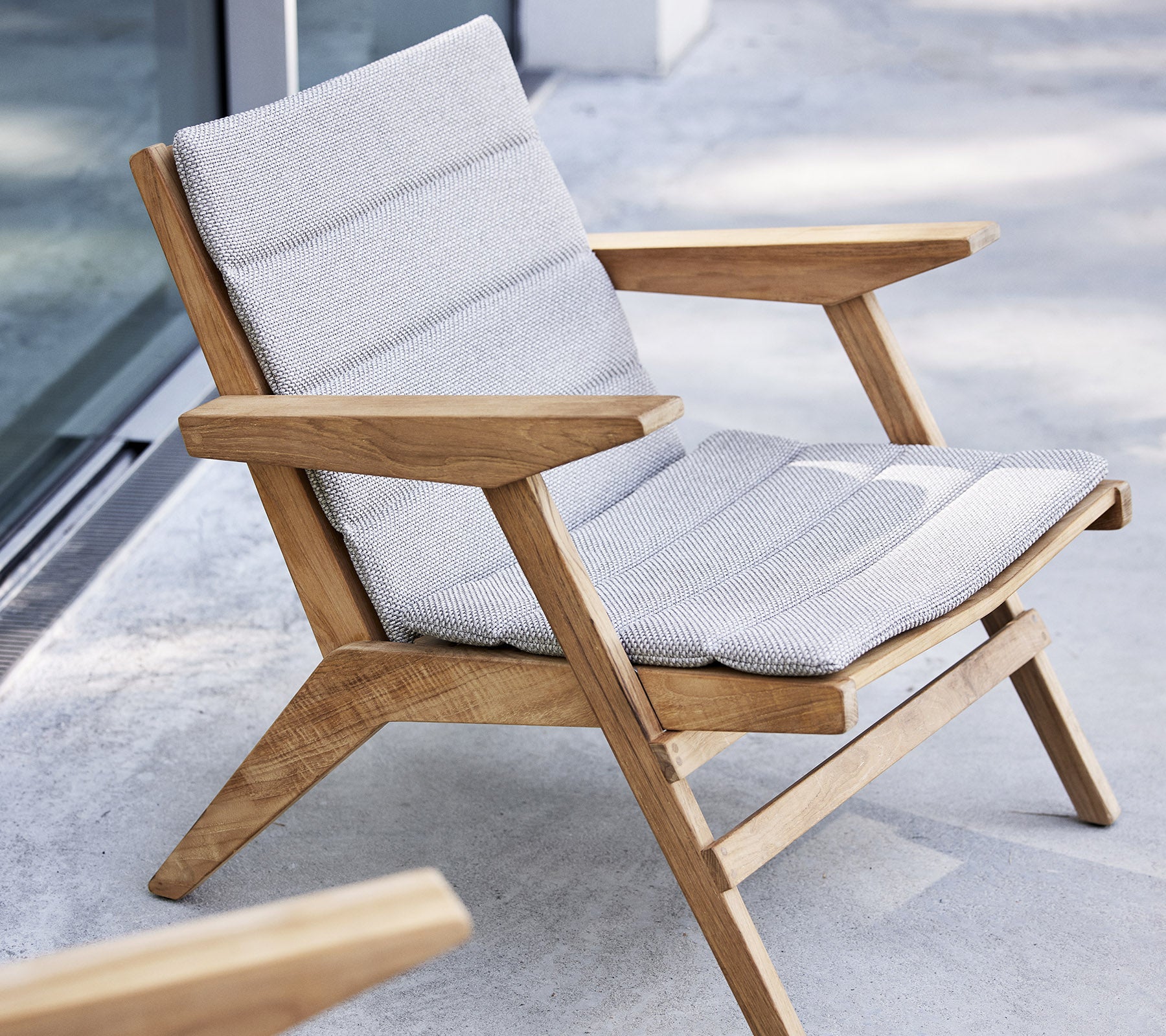 Stijlvolle loungestoel met een houten frame en een gevoerd zitvlak, ontworpen voor comfort en ontspanning.