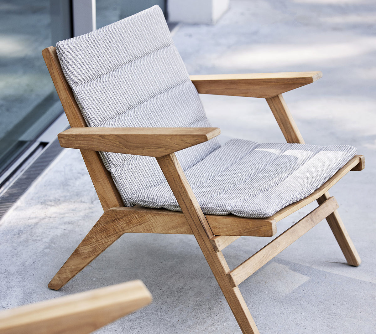 Stijlvolle loungestoel met een houten frame en een gevoerd zitvlak, ontworpen voor comfort en ontspanning.