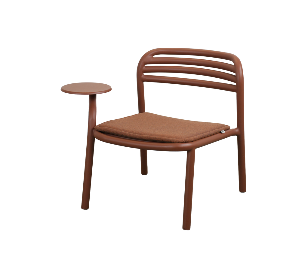 Moderne stoel in woestijnrood met een kleine salontafel.