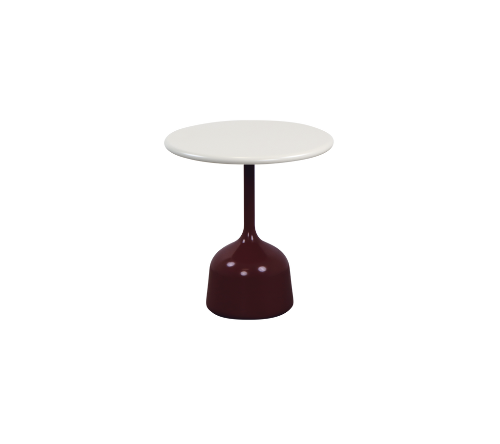 Modern bordeauxkleurige tafel met een witte tafelblad in een lounge-setting.