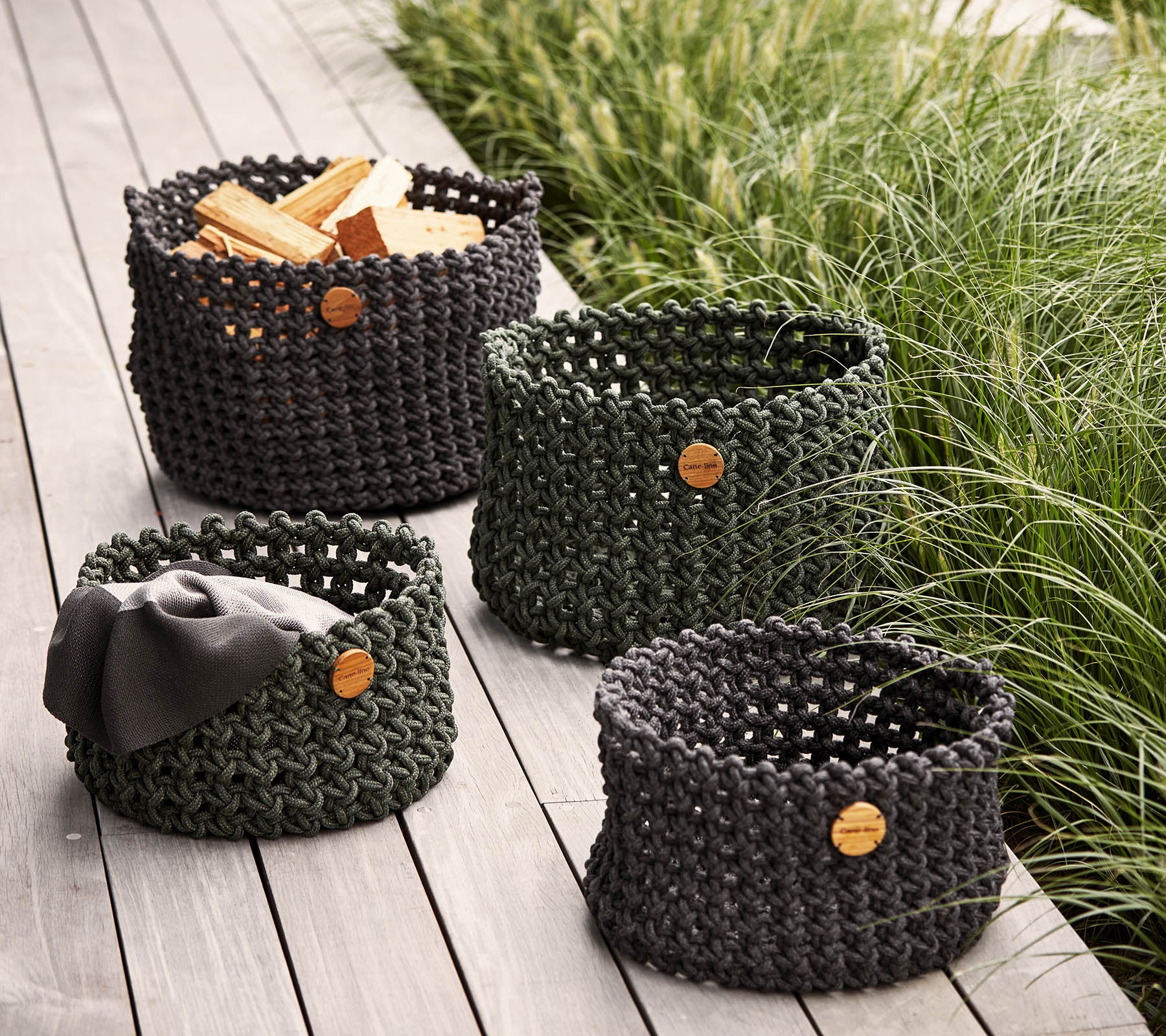 Set van vier gevlochten opbergmanden in verschillende maten, met natuurlijke houten labels, ideaal voor organiseren en decoreren.