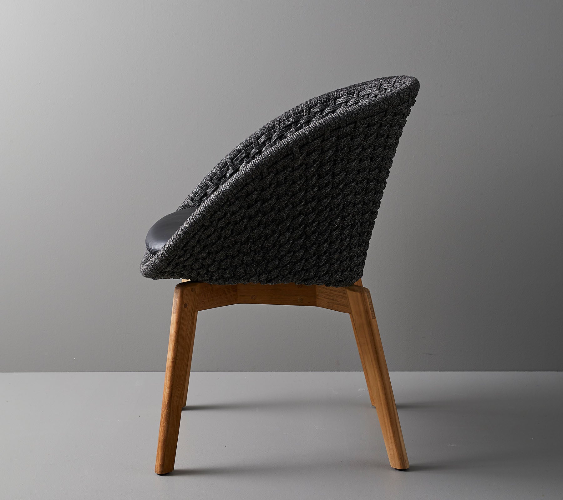 Stijlvolle stoel met een geweven rugleuning en houten poten, die een modern ontwerp biedt dat ideaal is voor hedendaagse ruimtes.