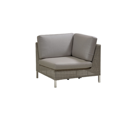 Stijlvolle hoekzitunit met een gevlochten frame en pluche kussens in neutrale tinten, perfect voor moderne decoratie.