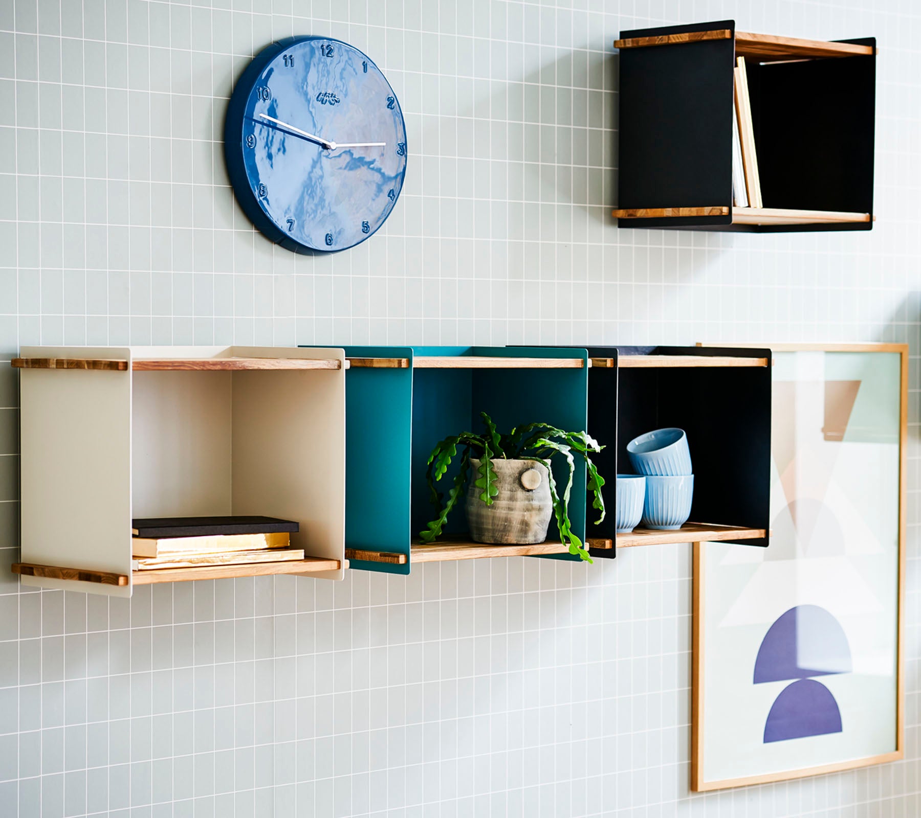 Een stijlvolle wanddisplay met kleurrijke opbergdozen, een ronde wandklok en ingelijste kunst voor een moderne esthetiek.