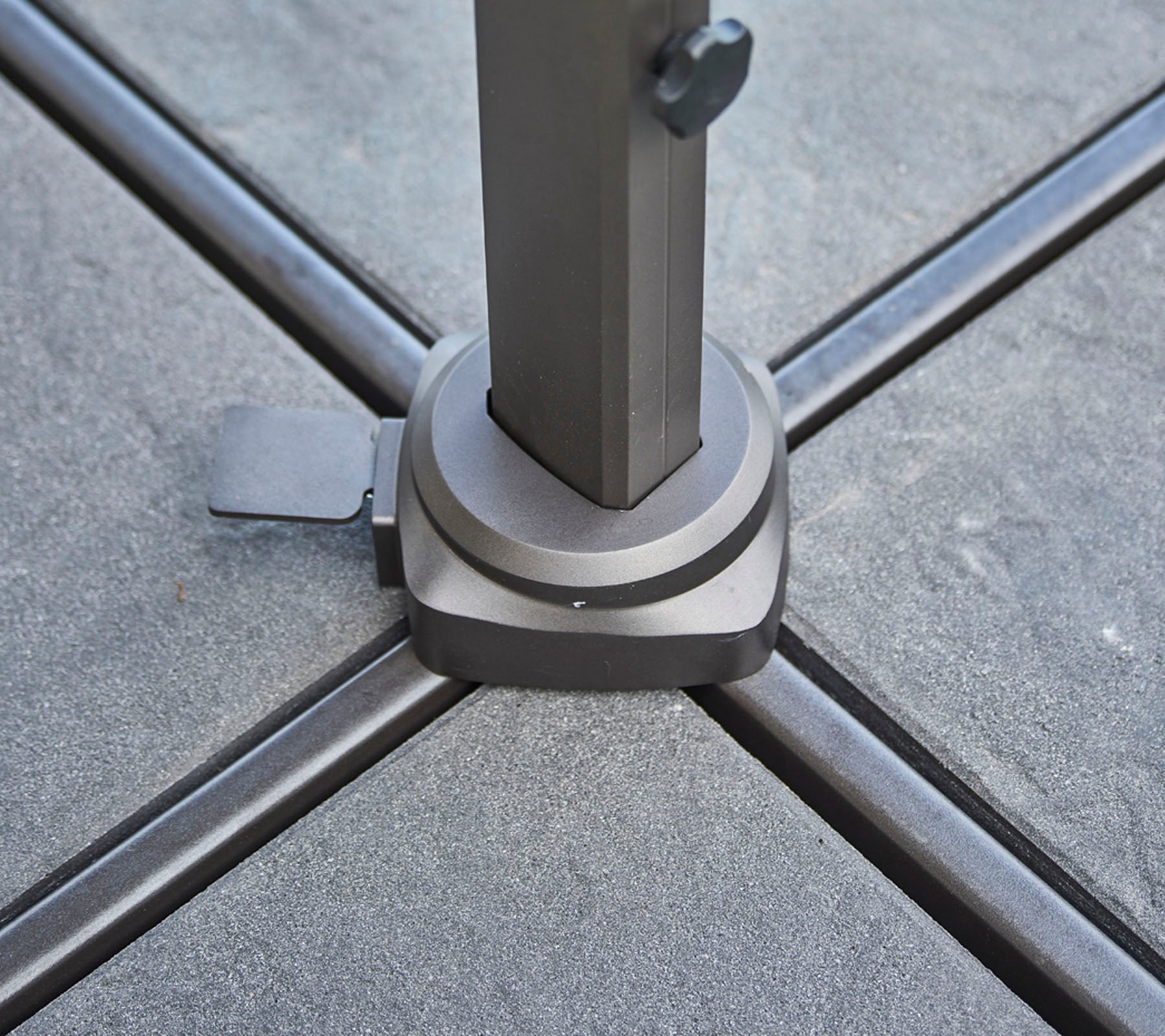 Basis van een stevige parasolpaal met een vergrendelmechanisme, ontworpen voor stabiliteit en ondersteuning op een vlakke ondergrond.
