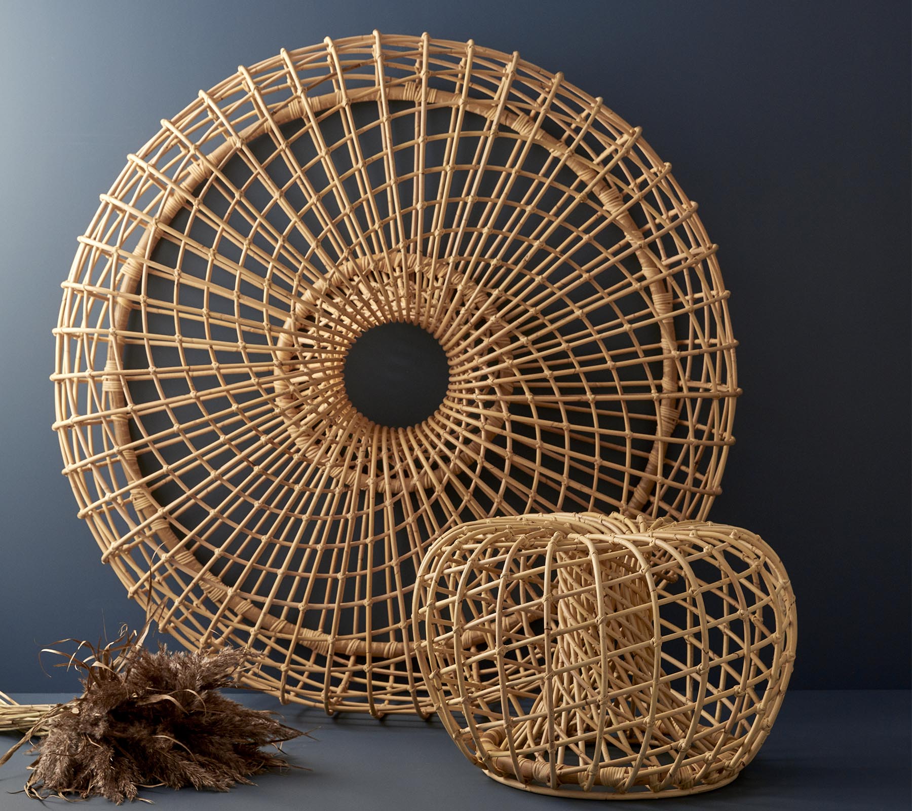 Geweven rieten decorstukken in een ronde vorm en een kubistisch ontwerp, met ingewikkelde patronen en natuurlijke texturen.