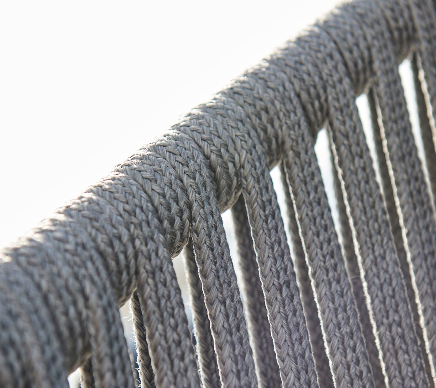 Close-up van grijze touwdetails, die de textuur en het patroon van een geweven ontwerp benadrukken.
