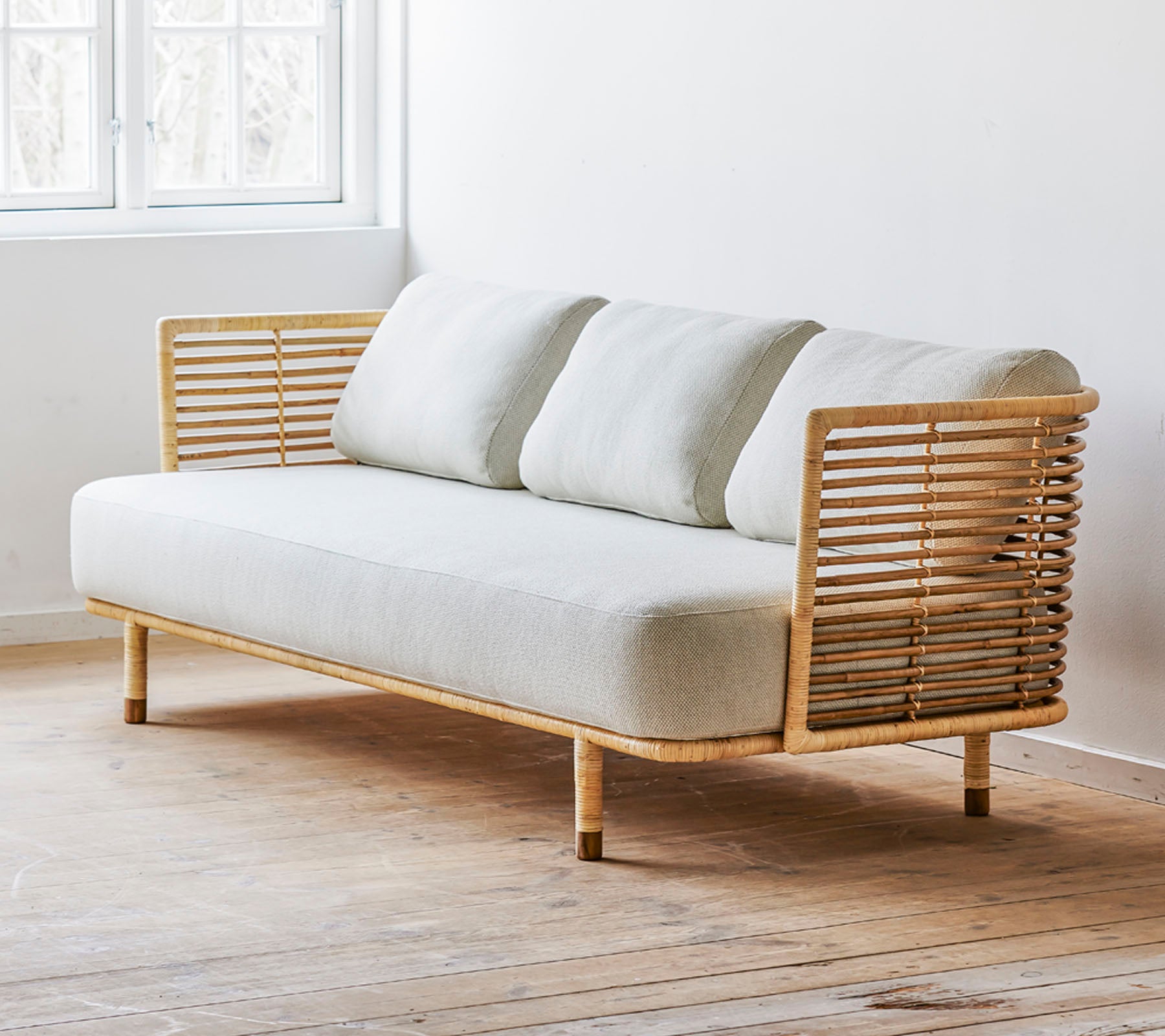 Een moderne bank met een strakke vormgeving, een lichte stoffen zitting en stijlvolle houten accenten. Perfect voor hedendaagse ruimtes.