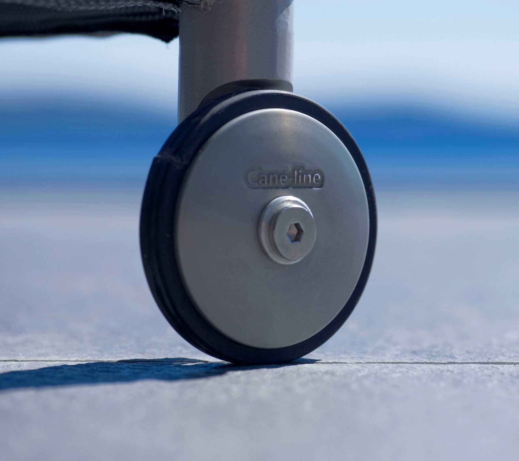Close-up van een duurzaam wielen met een metalen afwerking en een logo, ontworpen voor gemakkelijke mobiliteit en stabiliteit op verschillende oppervlakken.
