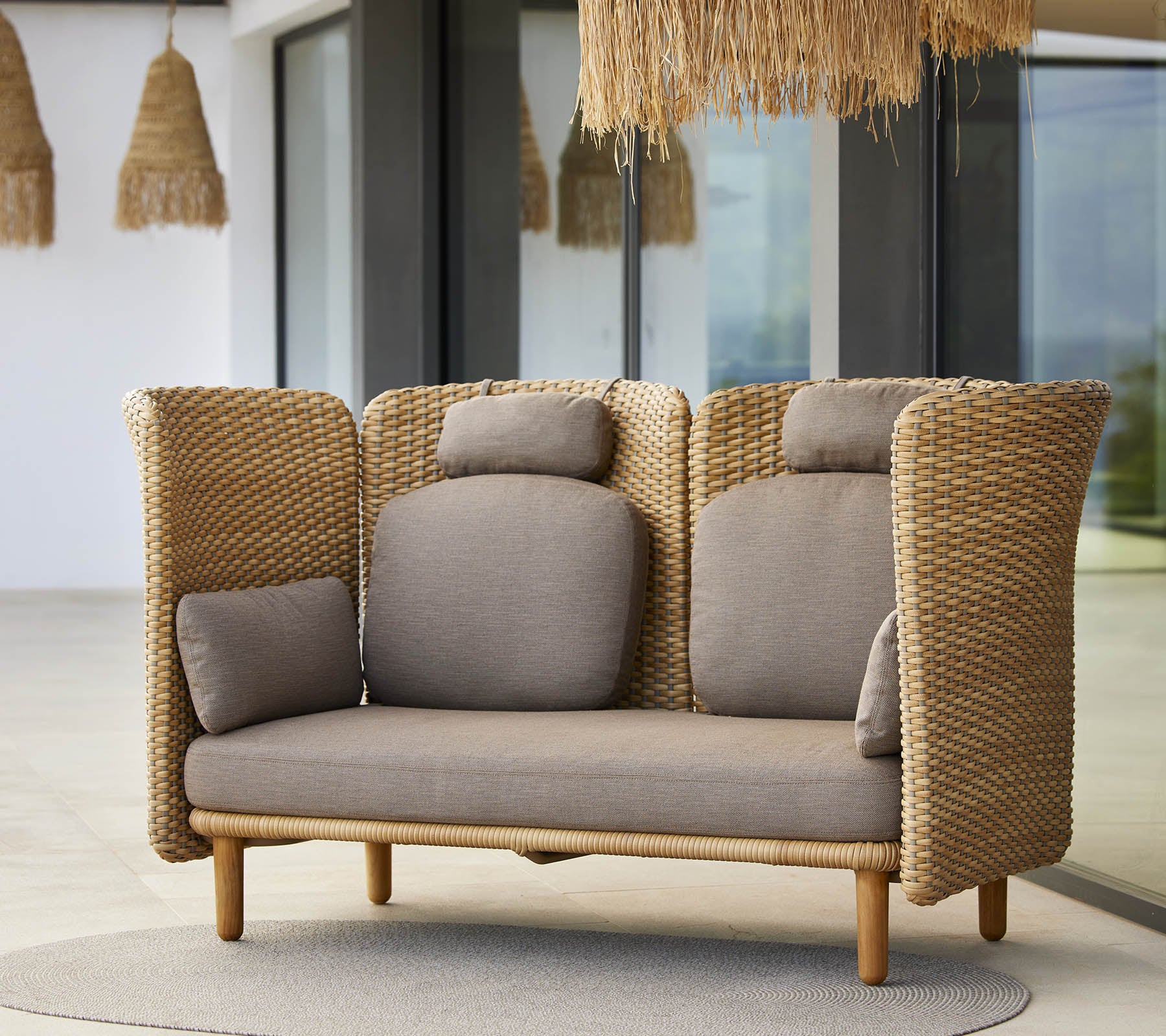 Een stijlvolle loungebank met geweven zijkanten en zachte kussens, ontworpen voor comfort en ontspanning. Ideaal voor moderne ruimtes.