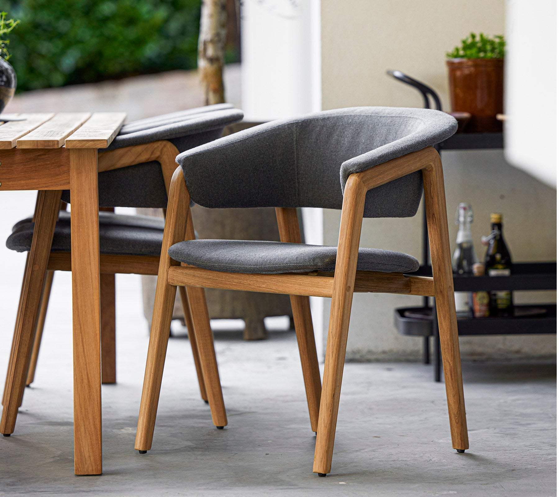 Stijlvolle stoel met een houten frame en grijze bekleding, ontworpen voor comfort en elegantie, perfect voor moderne omgevingen.