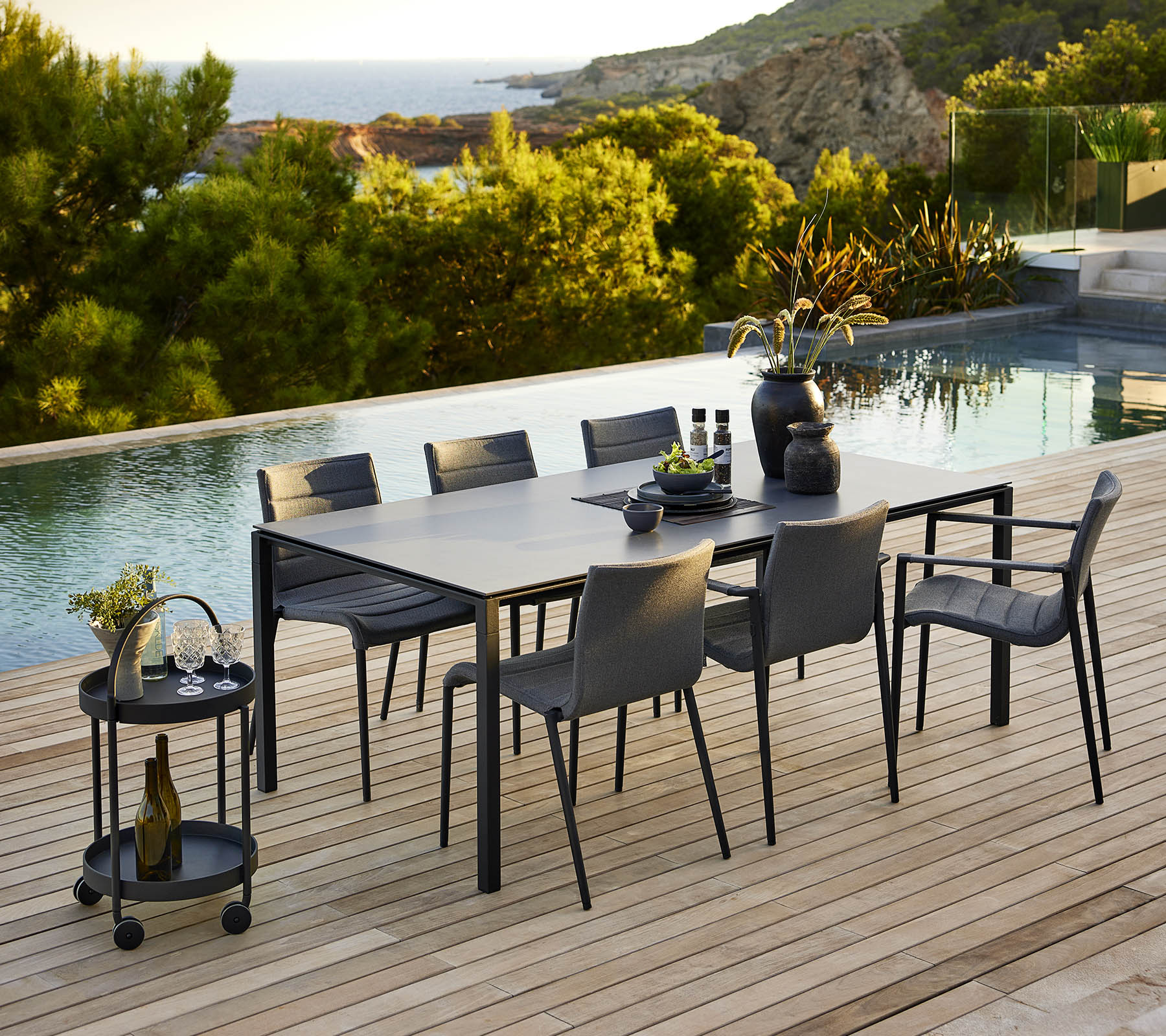 Stijlvolle dinersetting met een slanke tafel en bijpassende stoelen, aangevuld met decoratieve accessoires en een serene buitenachtergrond.