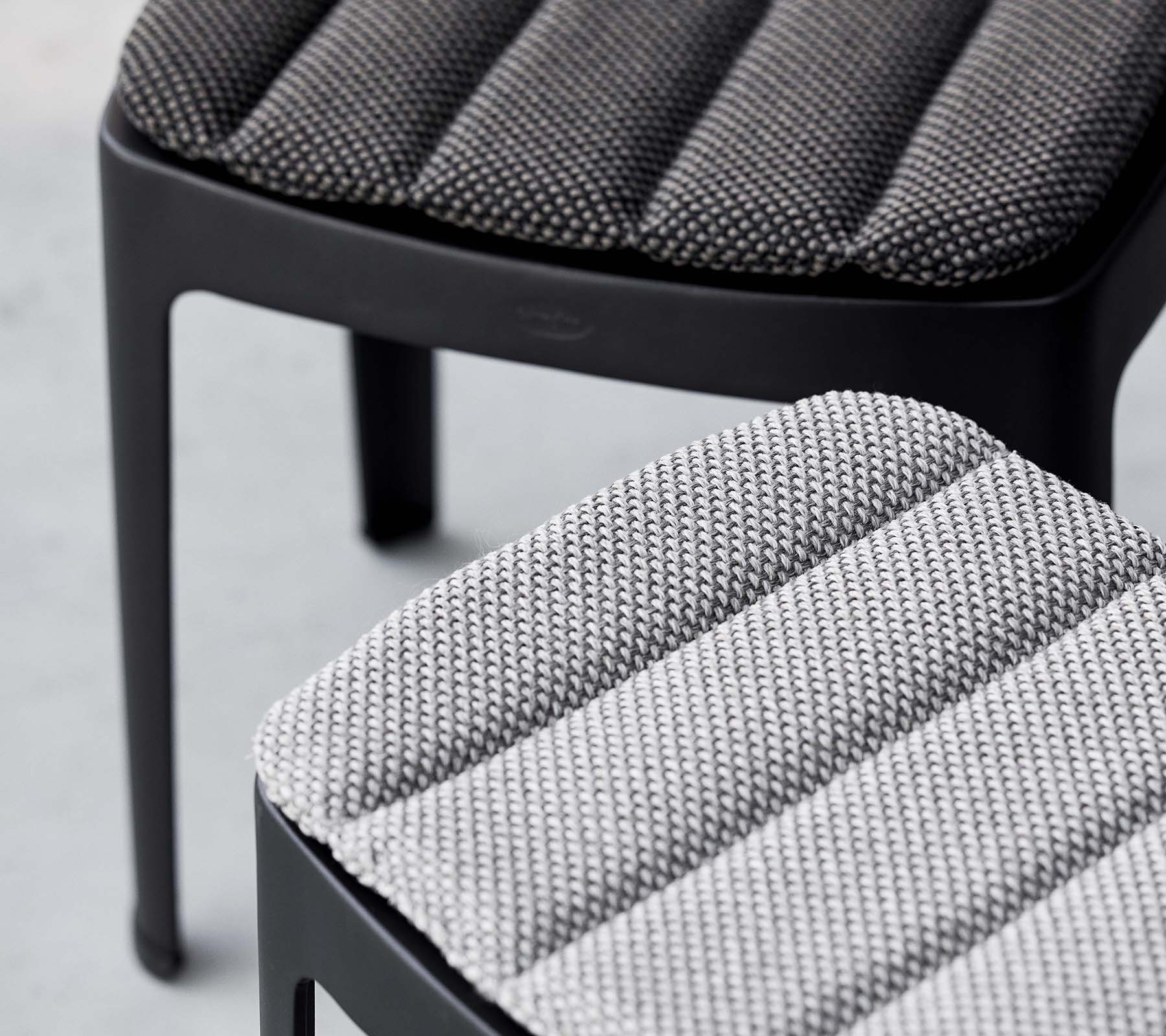 Twee stijlvolle krukken met gestructureerde bekleding in contrasterende grijstinten, die een modern ontwerp met slanke lijnen tonen.