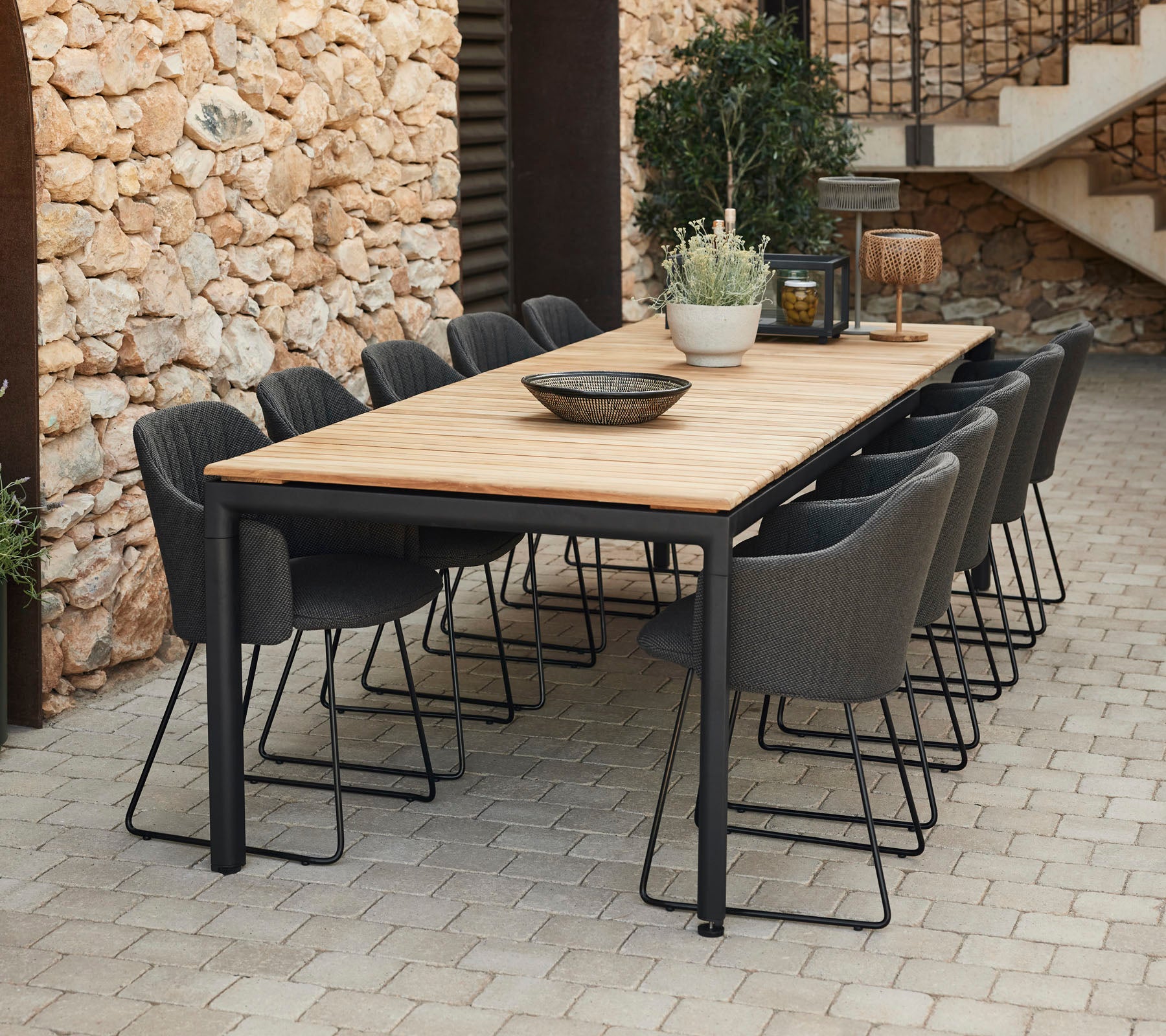 Elegante eettafel met een houten blad en zwarte metalen poten, omringd door grijze stoelen, perfect voor bijeenkomsten.