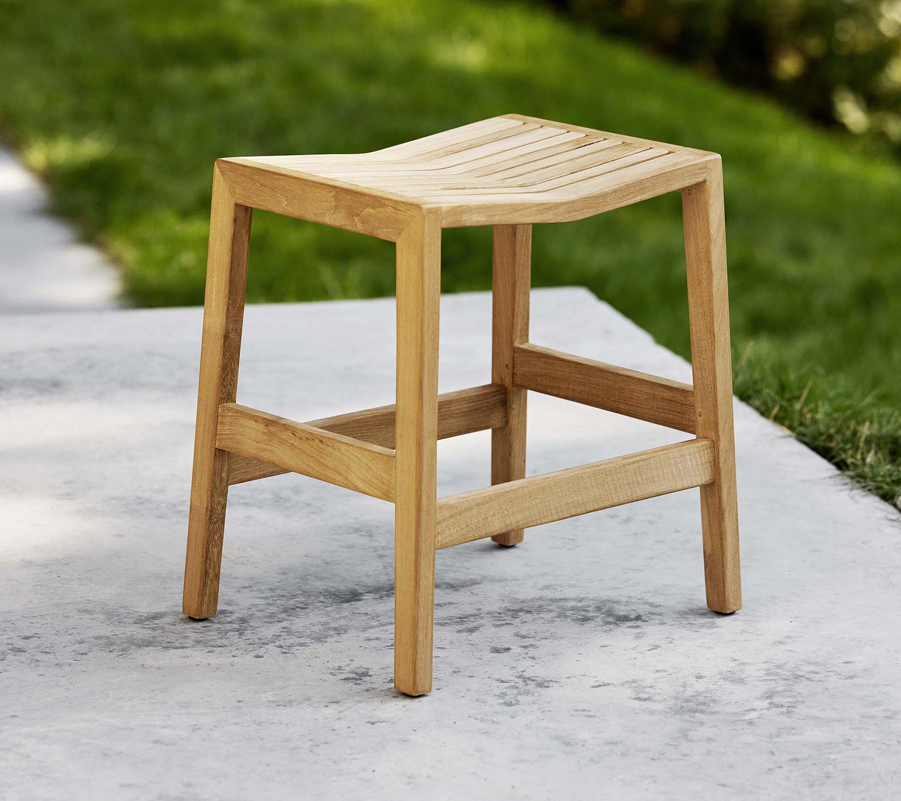 Een houten opklapstoel met een latten zitting en stevige benen, ontworpen voor veelzijdig gebruik als zitplek of decoratie.