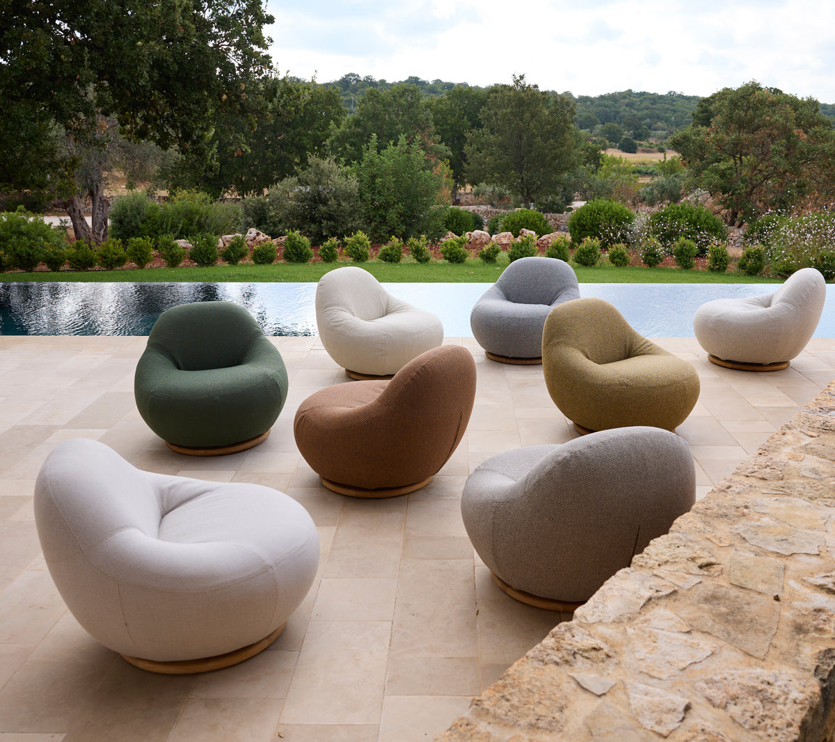 Set van moderne stoelen in verschillende kleuren rond een zwembad geplaatst.