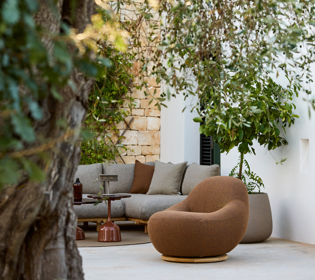 Modern lounggebied met een bruine stoel en een grijze hoekbank.