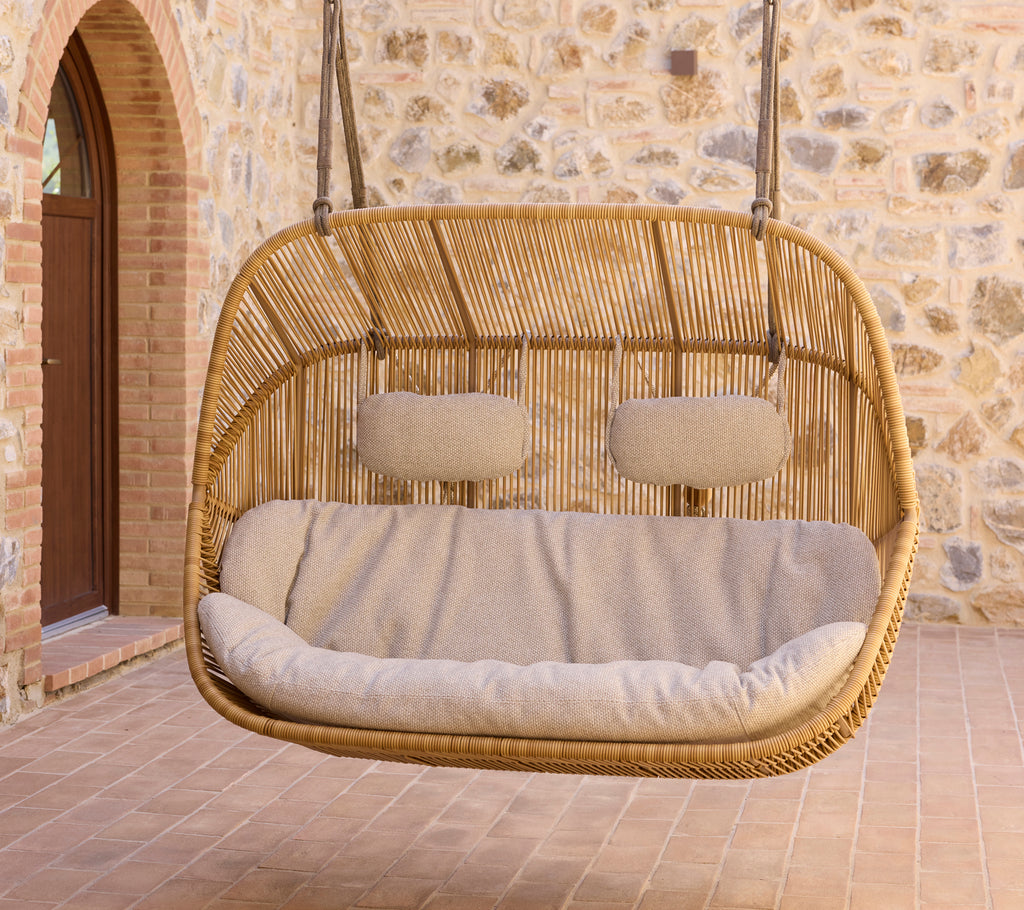 Hangende Hive-sofa met pluche verhoogde kussens, met een natuurlijk geweven ontwerp en een gezellige zithoek. Perfect voor ontspanning.