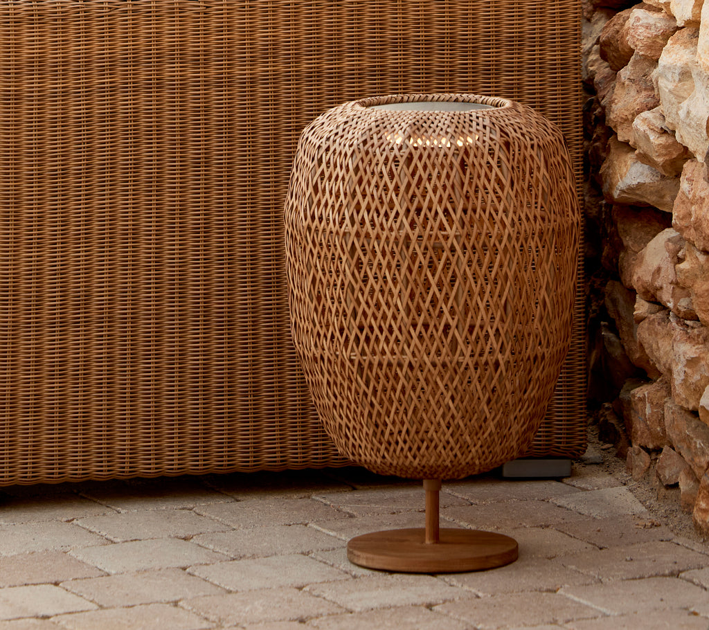 Een gemiddelde tafel lamp met een geweven ontwerp, met een ronde basis en een intrigerend lichtgloei-effect. Perfect voor het verbeteren van de ambiance.