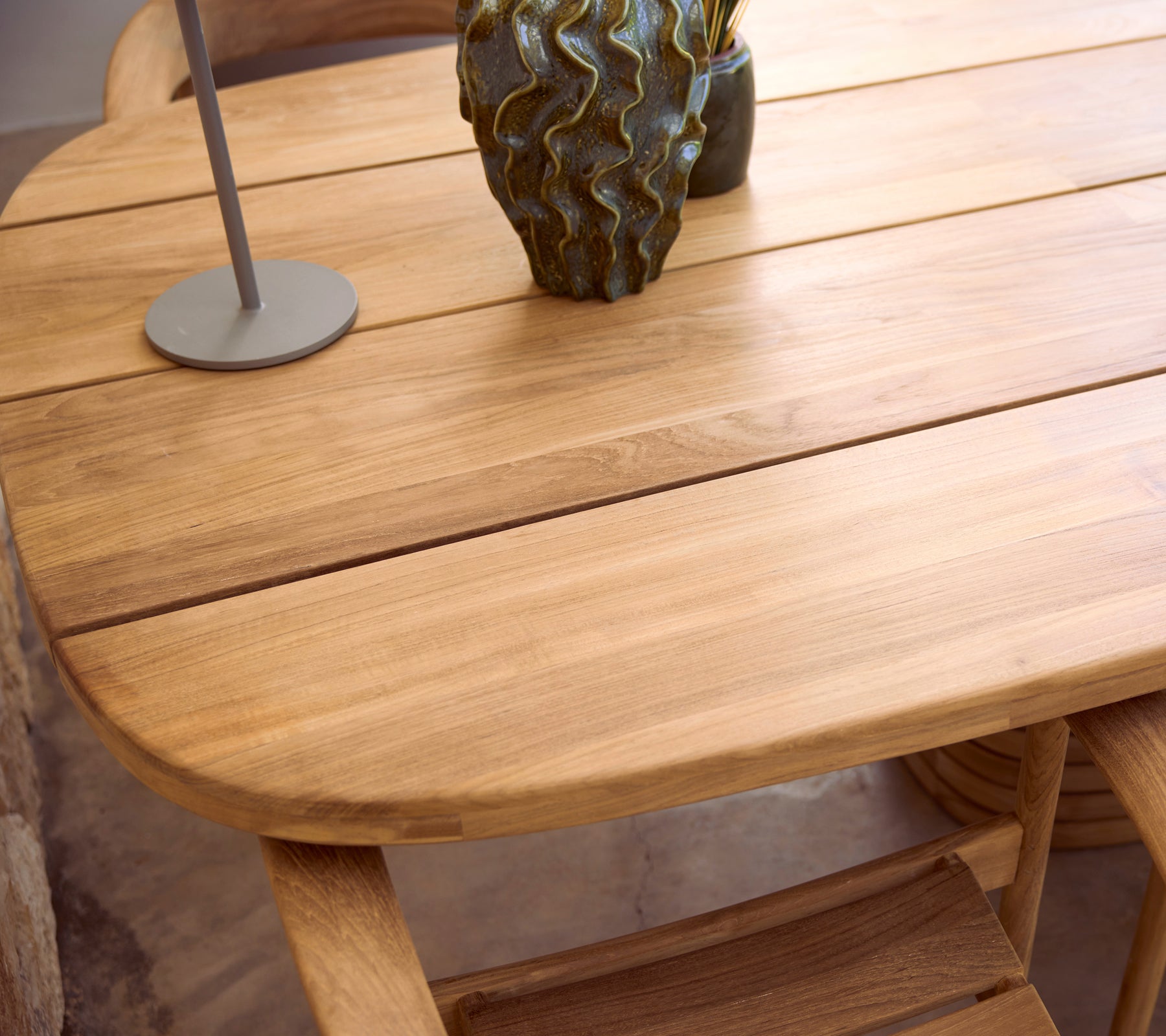 Modern houten tafel met een lamp en een decoratieve vaas.
