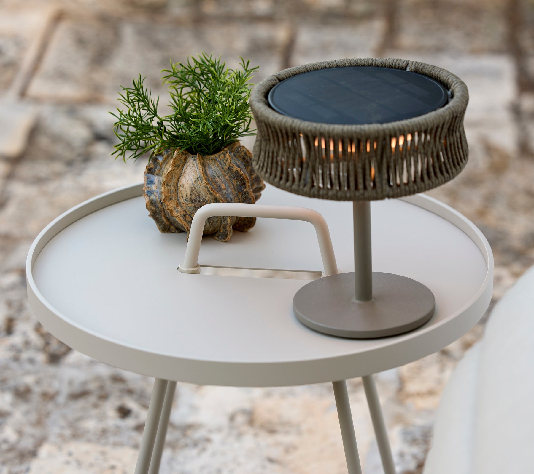 Moderne grijze salontafel met een groene plant en een stijlvolle tafel lamp.