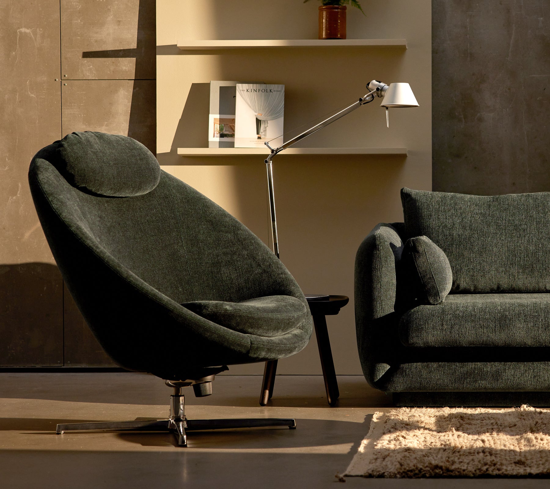 Pace stoel in donkergroene chenille naast een Bloom bank, aangevuld met een slanke lamp en minimalistische wanddecoratie.