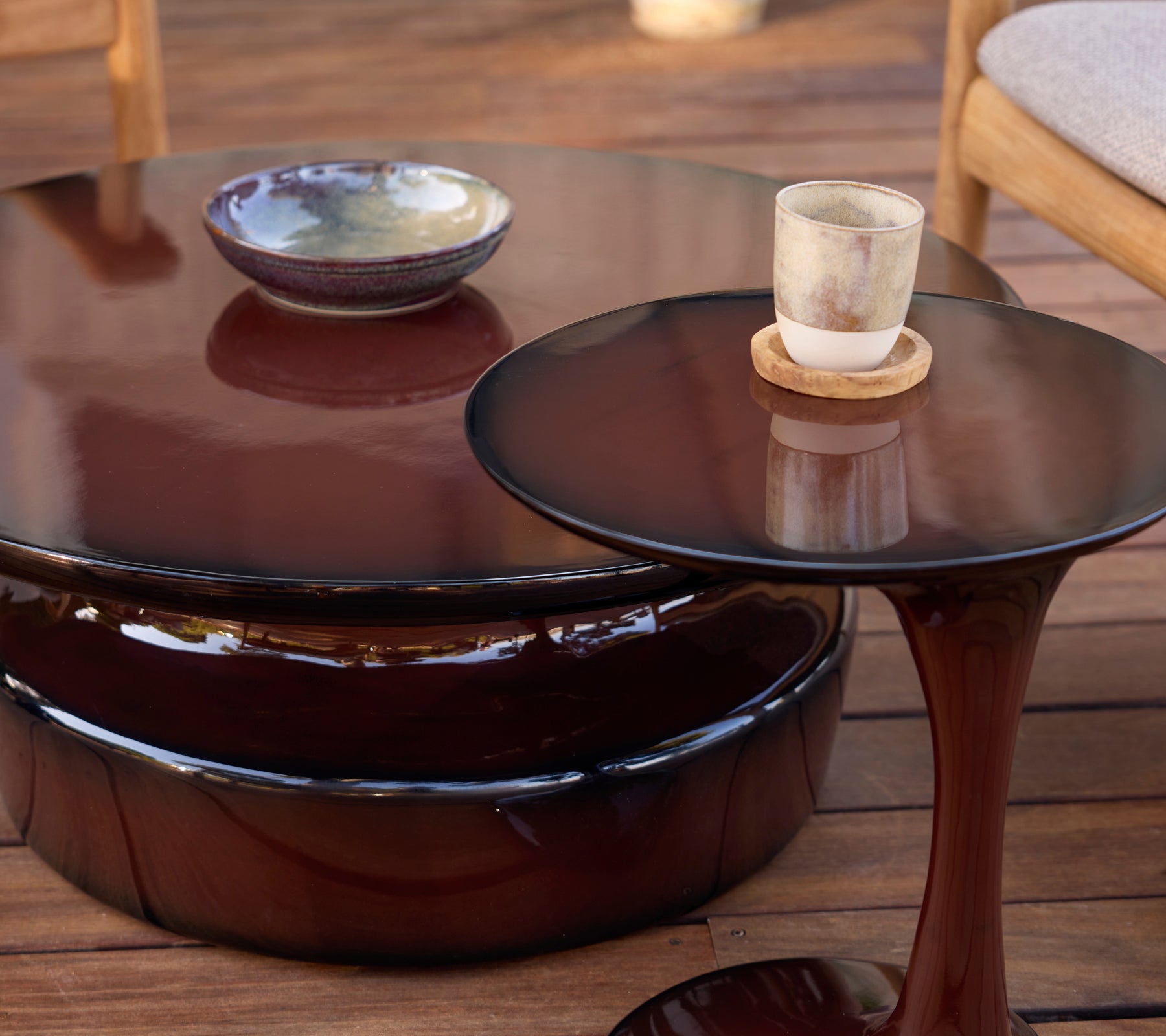 Moderne bruine koffietafels en bijzettafels met keramische kom en glazen kaars.