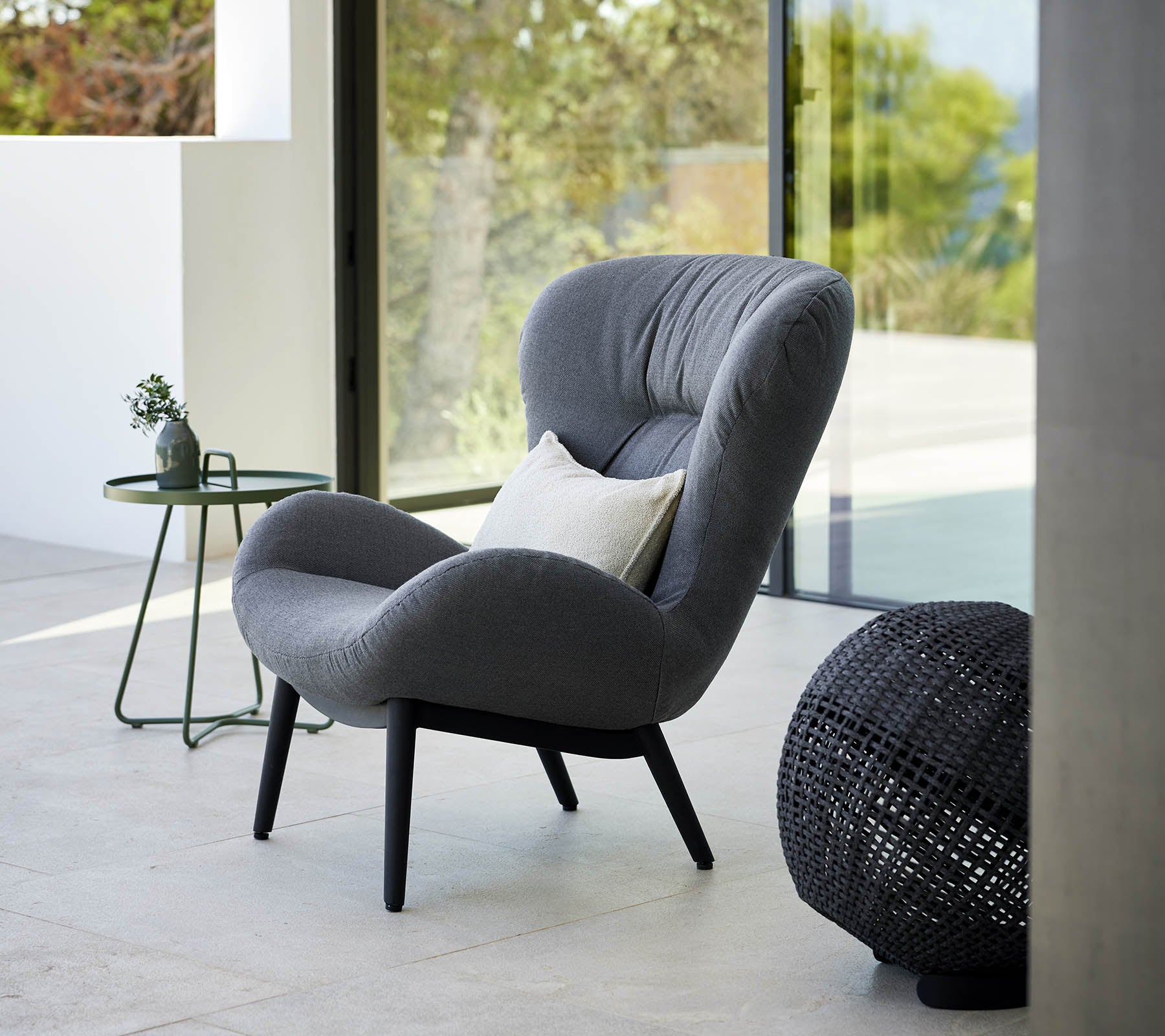 een rustige lounge stoel met een modern ontwerp, met zachte bekleding en elegante poten, vergezeld van een klein bijzettafeltje en decoratieve accenten.