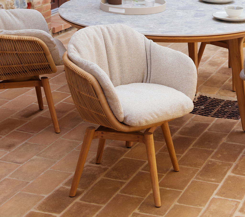 Cozy dining chair with a soft cushion and sleek teak legs, featuring a unique swivel design for comfortable seating.