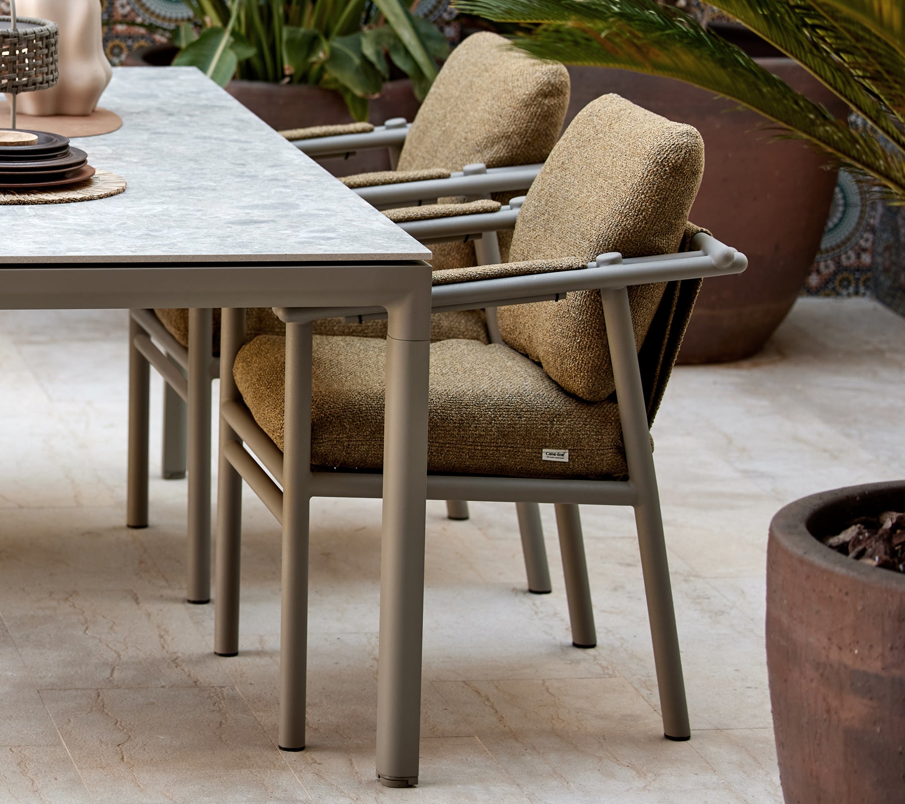Twee eetstoelen met zachte kussens, met een modern design en stevige poten, geplaatst naast een tafel met decoratieve items.
