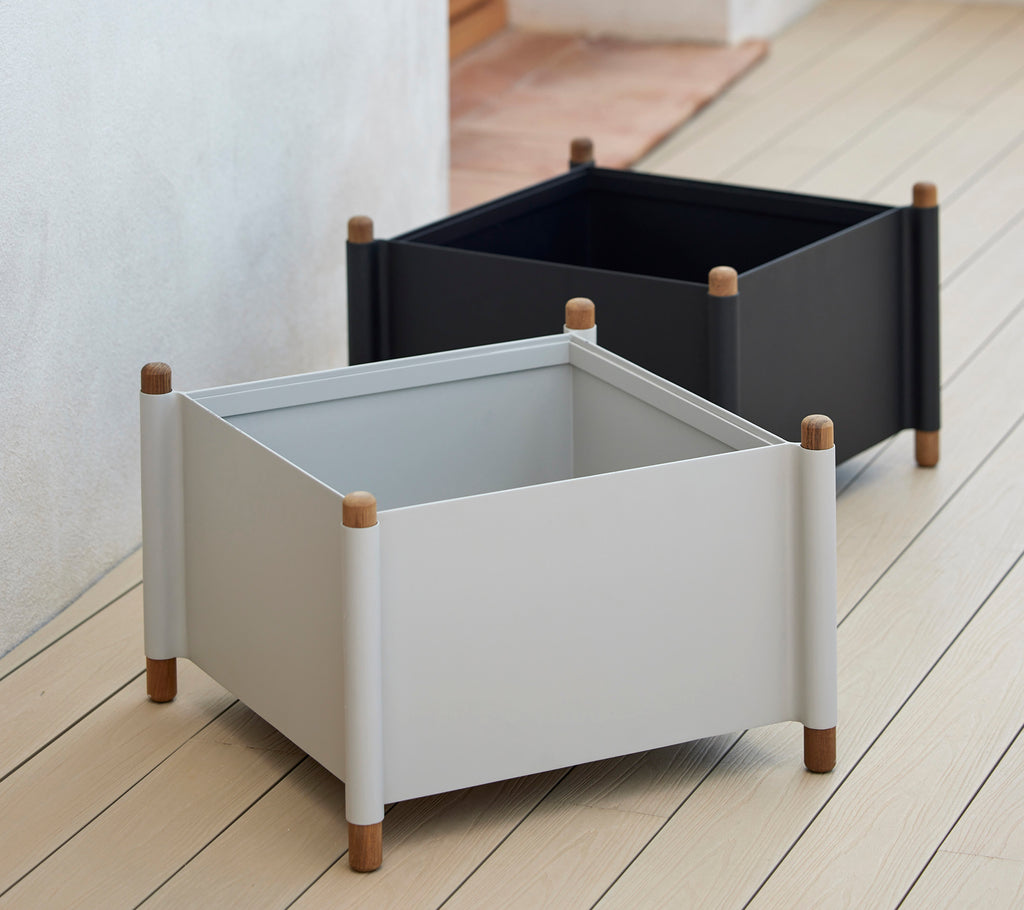 Twee vierkante plantenbakken in grijs en zwart met houten poten, ontworpen voor moderne decoratie en geschikt voor verschillende planten.